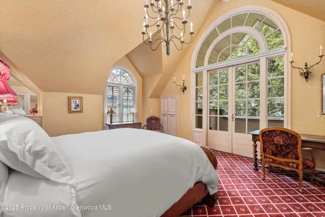 a spacious bedroom with a bed and a large window