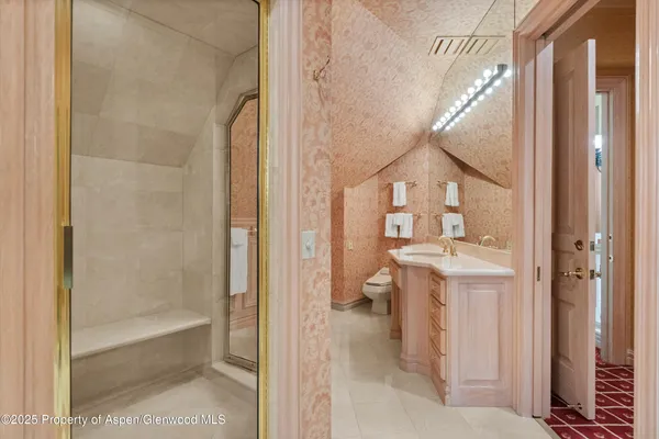 a bathroom with a sink and mirror with bathtub