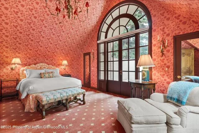 a bedroom with a bed and a large window