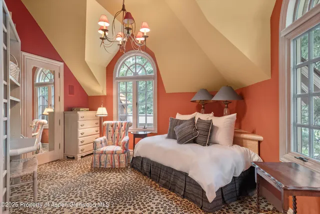 a bedroom with a bed and a chandelier