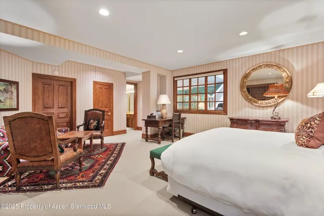 a bed room with a bed a dresser and a large window