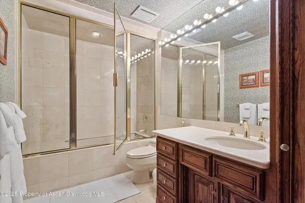 a bathroom with a sink a toilet a mirror and shower