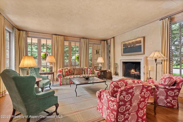 a living room with furniture large window and a fireplace
