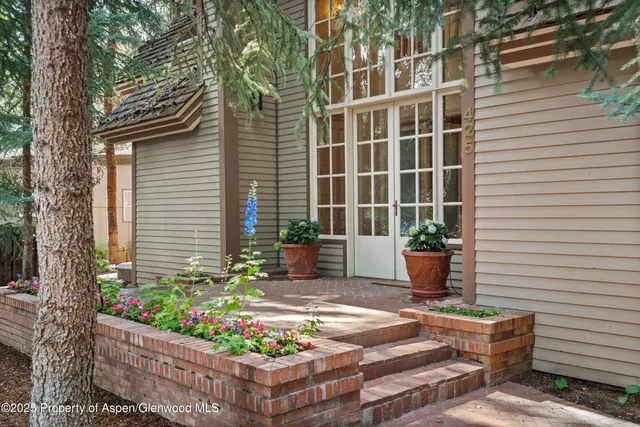 a front view of a house with a yard and potted plants