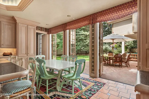 a dining room with furniture and large windows