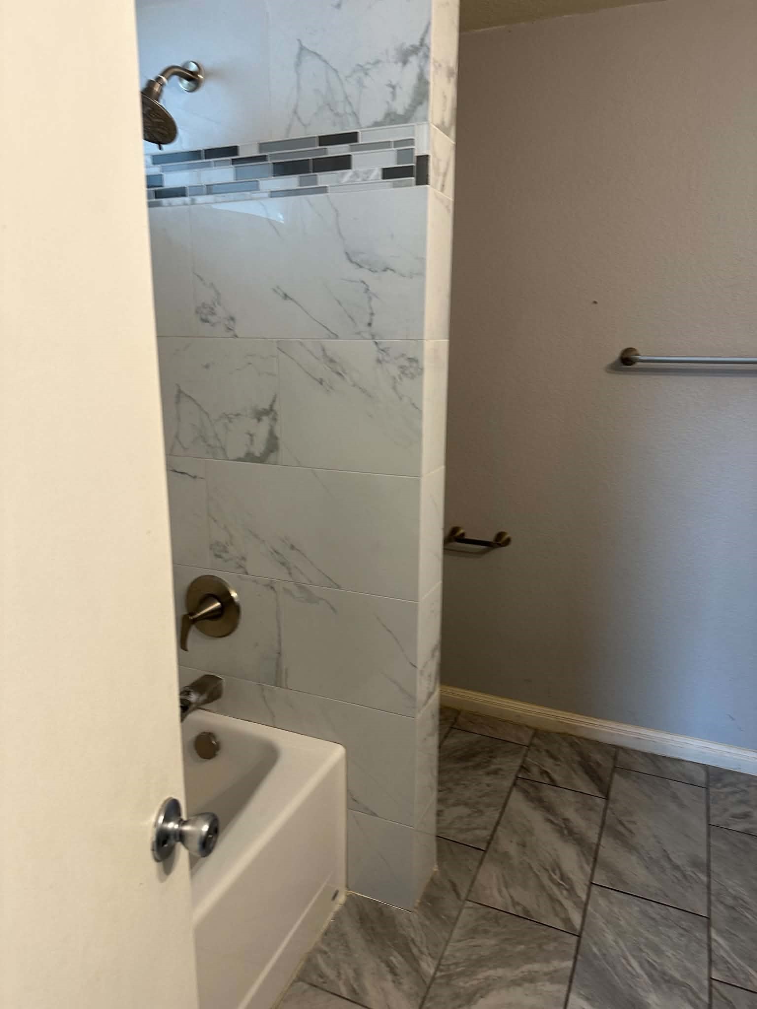 18312 Crestwind Lane Elgin, TX 78621 - Photo 11 of 15 Gleaming tile work elevates this full bathroom, offering a contemporary and refreshing space.