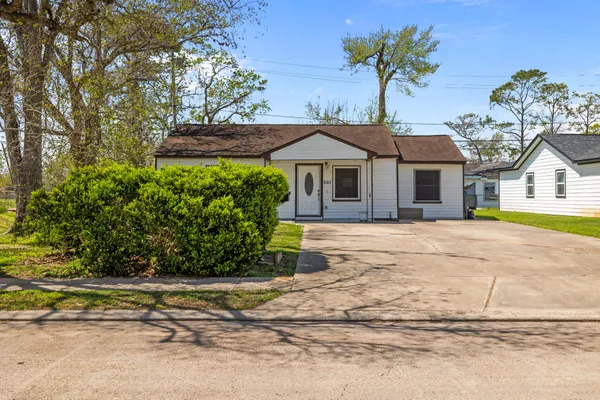 a front view of a house with a yard and potted plants