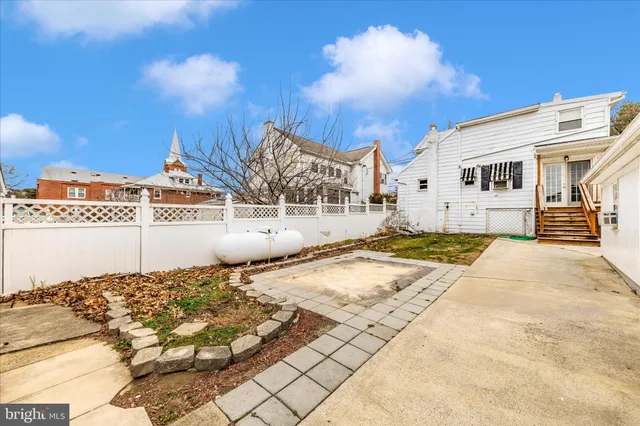 a view of a large white house with a yard