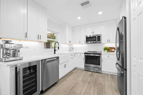a kitchen with a sink cabinets and stainless steel appliances