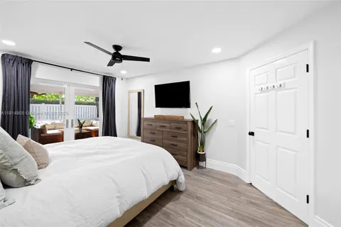 a spacious bedroom with a bed and a flat screen tv