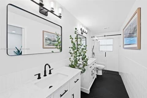 a bathroom with a sink and mirror with toilet