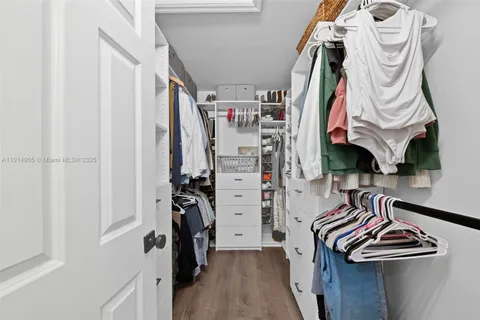 a view of walk in closet with clothes and shoes