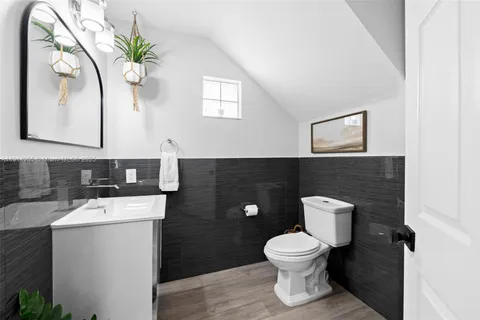 a bathroom with a toilet a sink and mirror