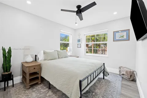 a bedroom with a bed a chandelier and a flat tv