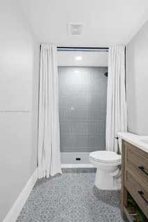 a bathroom with a shower a toilet and sink