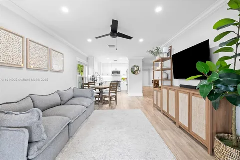 a living room with furniture a potted plant and a flat screen tv