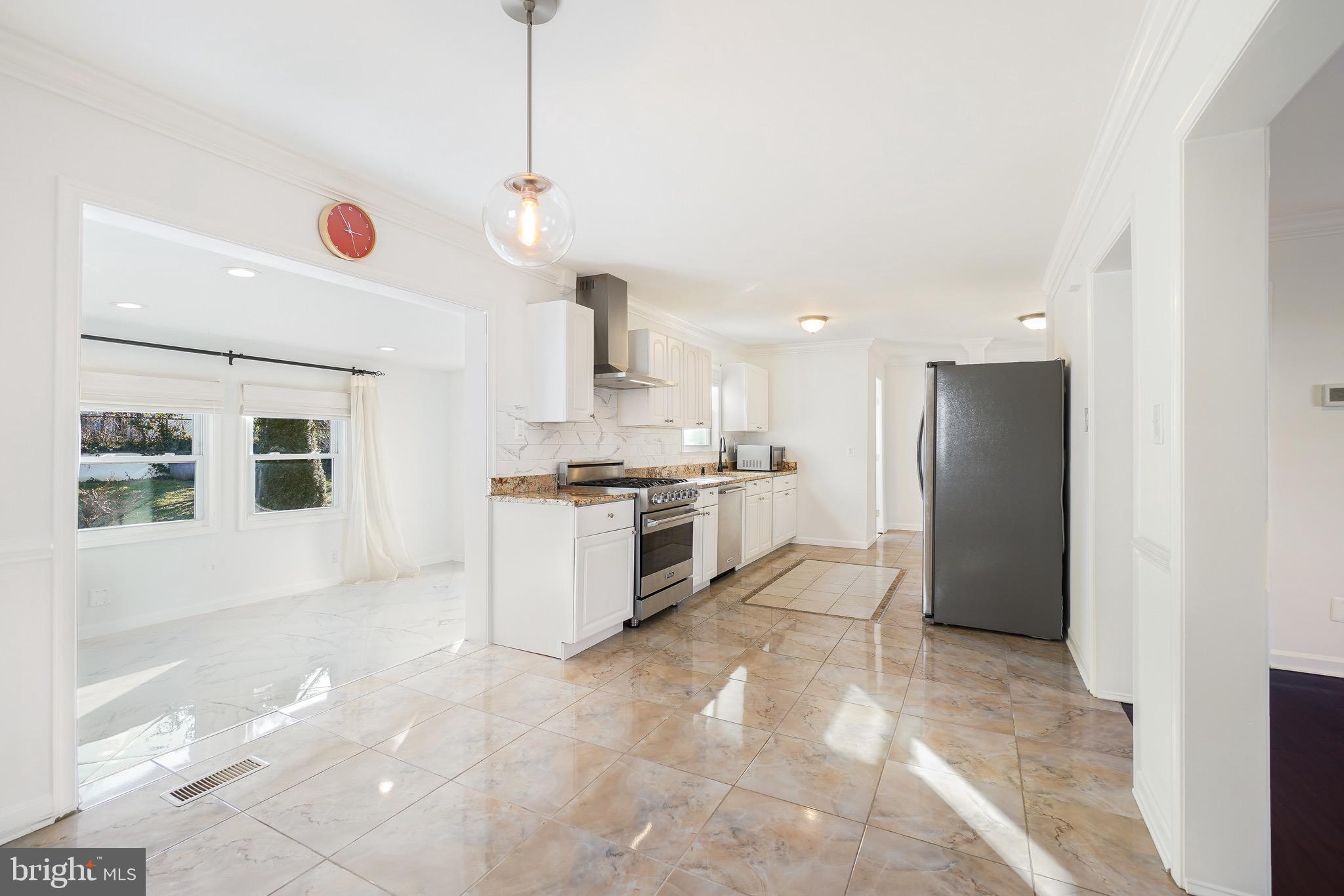 4712 Listra Road Rockville, MD 20853 - Photo 7 of 30 a kitchen with stainless steel appliances kitchen island granite countertop a refrigerator and a stove