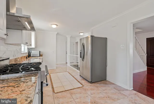 a kitchen with stainless steel appliances granite countertop a refrigerator and a stove