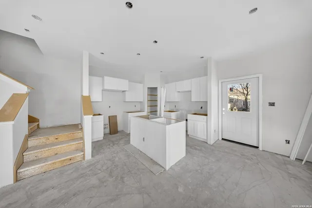 a view of kitchen with furniture and white appliances