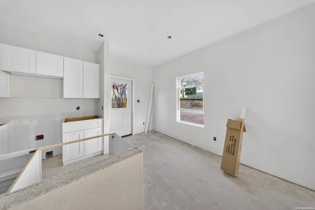 a view of a kitchen with white cabinets and white appliances