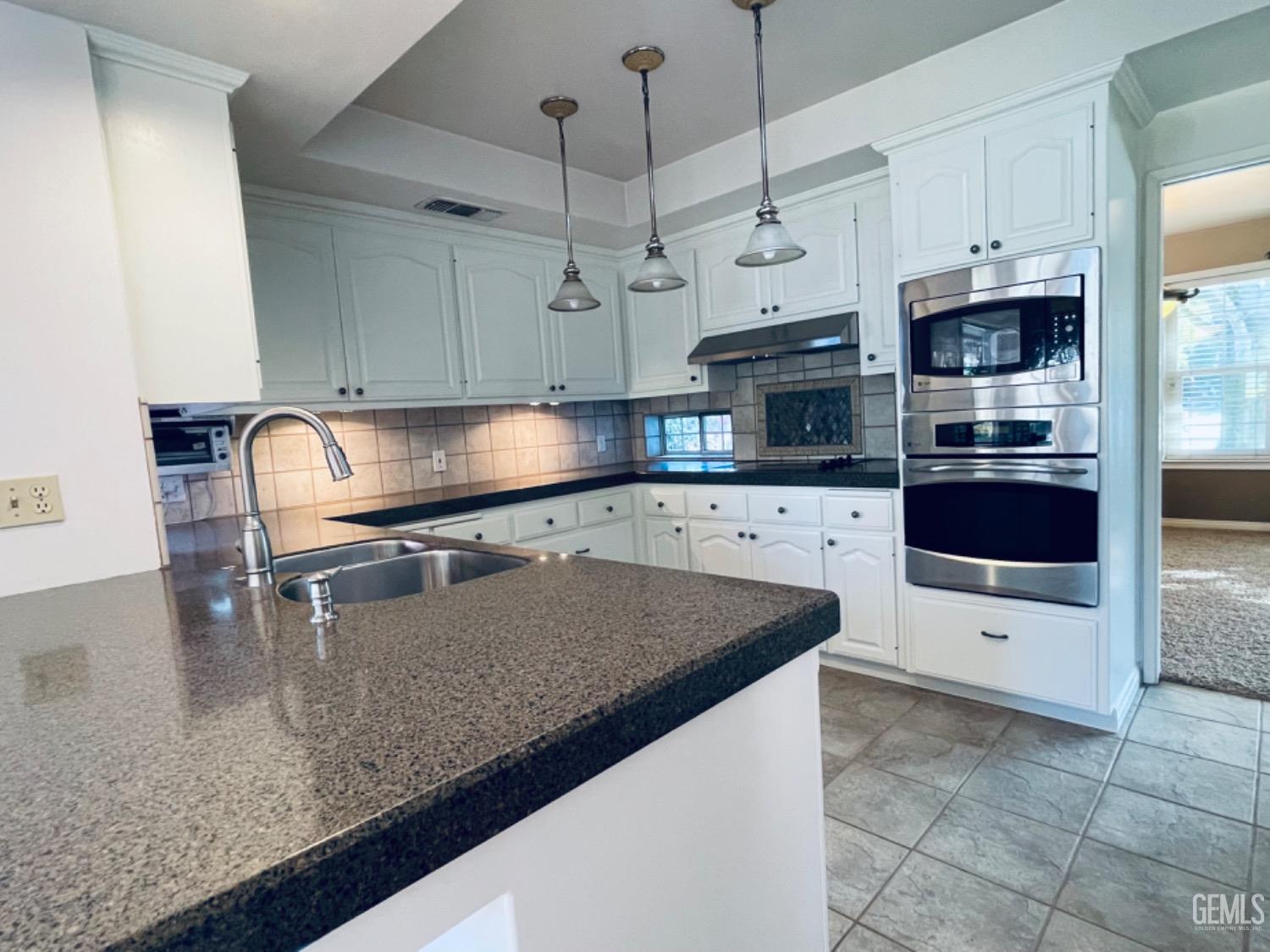 Undisclosed Address Shafter, CA 93263 - Photo 13 of 41 a kitchen with stainless steel appliances granite countertop a sink a stove top oven a counter space and cabinets