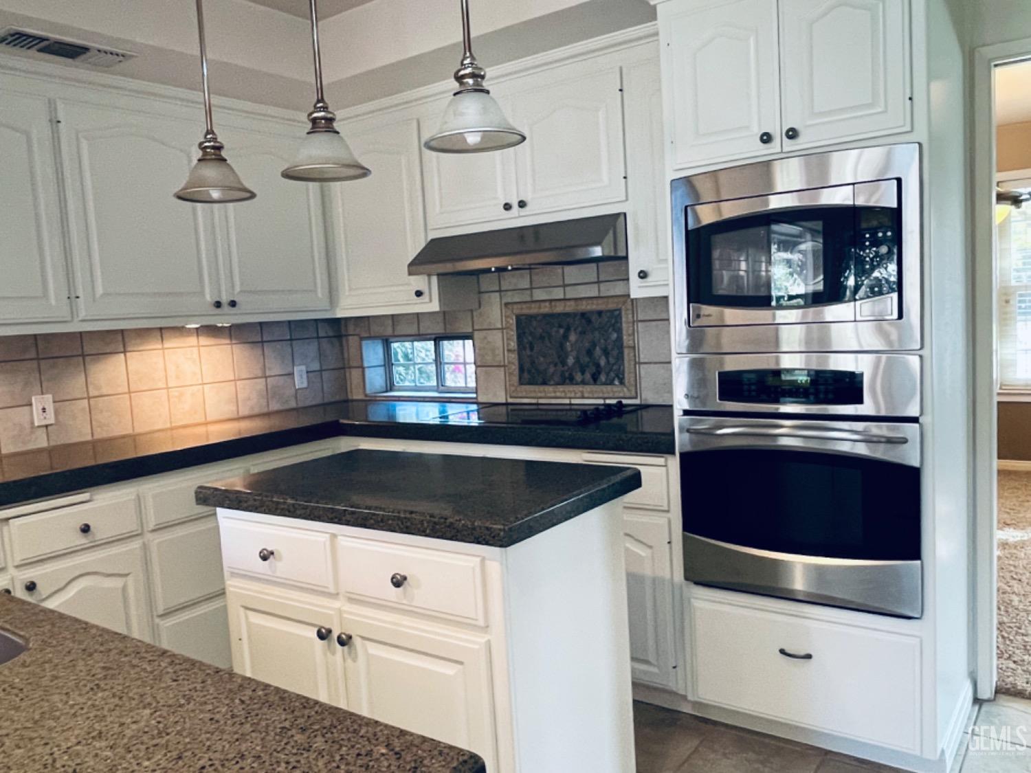 Undisclosed Address Shafter, CA 93263 - Photo 14 of 41 a kitchen with granite countertop white cabinets and stainless steel appliances