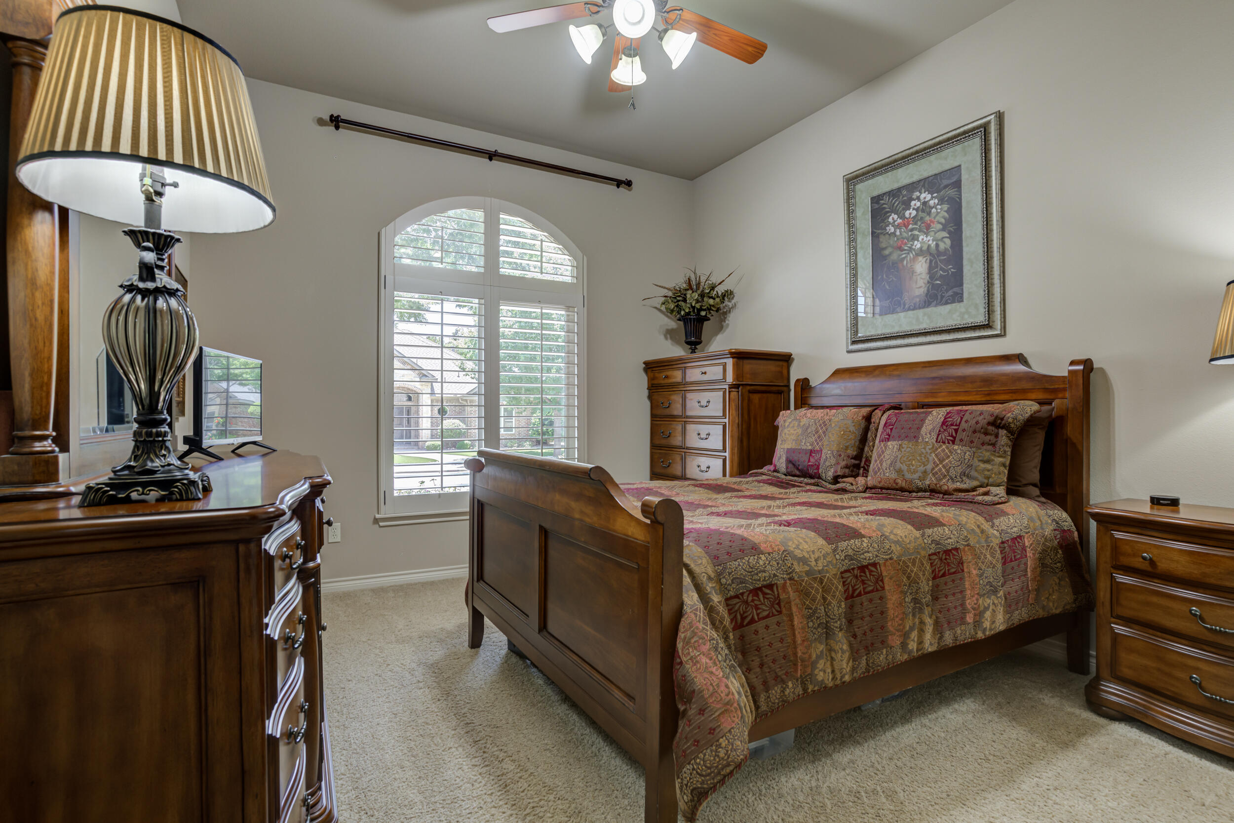 6008 89th Street Lubbock, TX 79424 - Photo 43 of 61 a bedroom with a bed and a chandelier