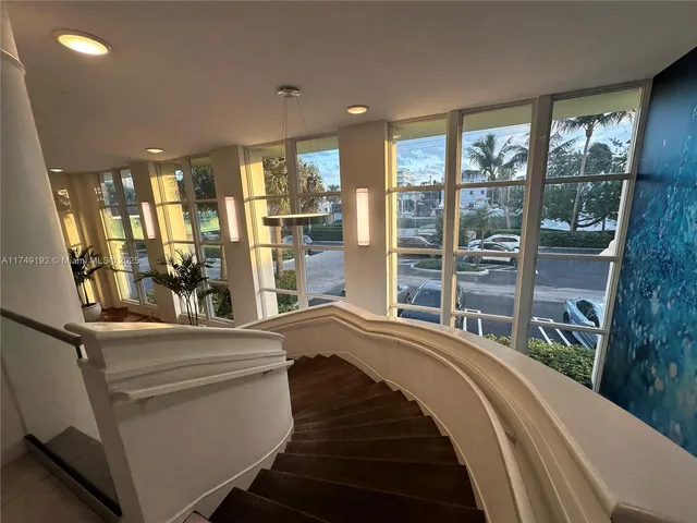 a large hall with stainless steel appliances kitchen island granite countertop a large counter top and a stove top oven