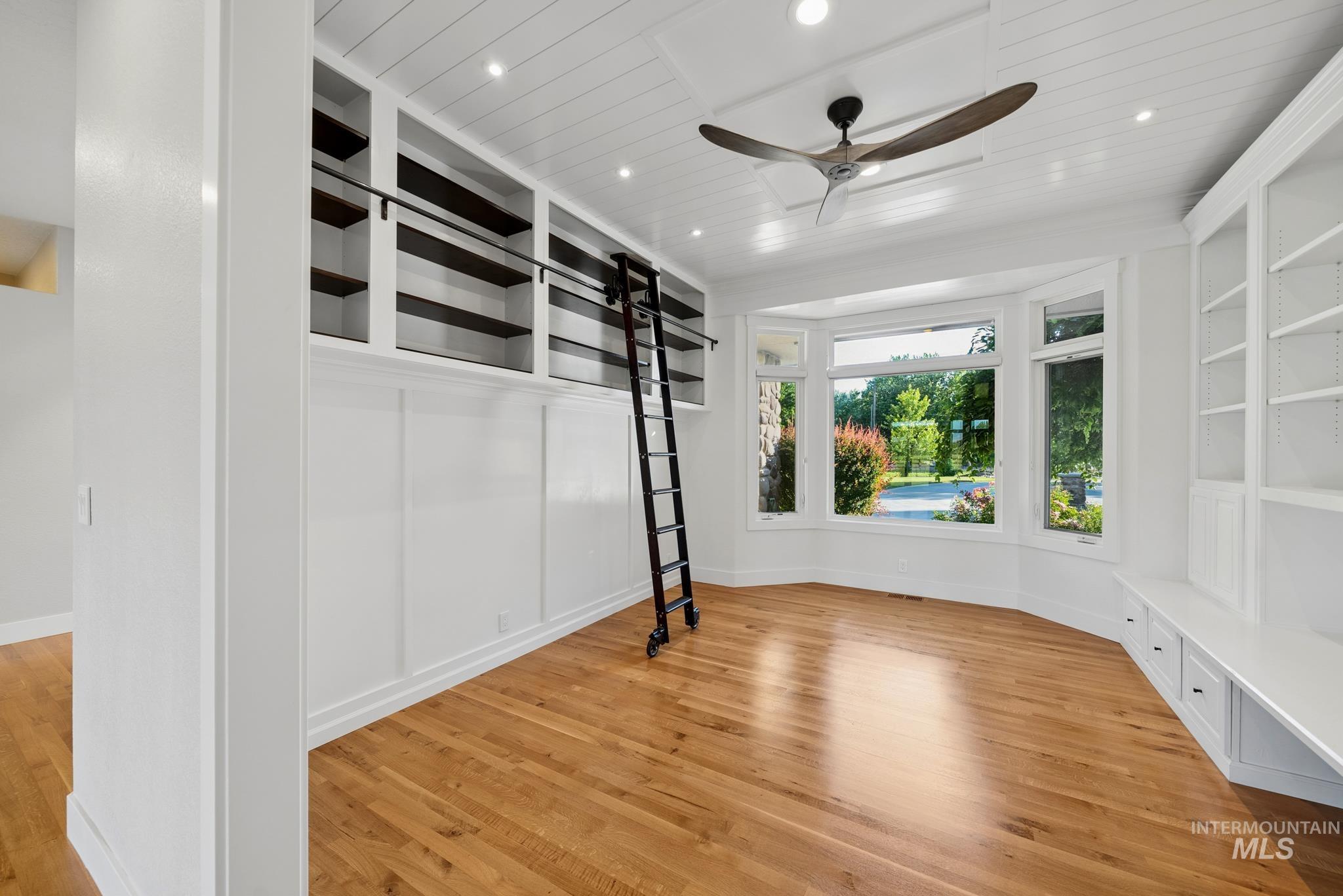 2050 Artesian Road Eagle, ID 83616 - Photo 19 of 49 Spacious room featuring a bay window, built-in shelving with a rolling ladder, wood-finish flooring, and recessed lighting