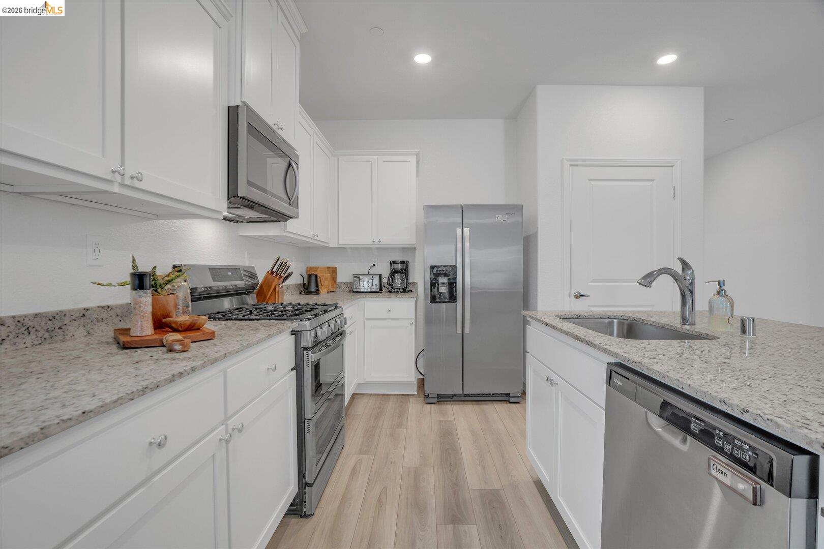 4463 Canada Way Rio Vista, CA 94571 - Photo 12 of 36 kitchen with stainless steel appliances, light stone counters, white cabinets, light wood-style flooring, and recessed lighting