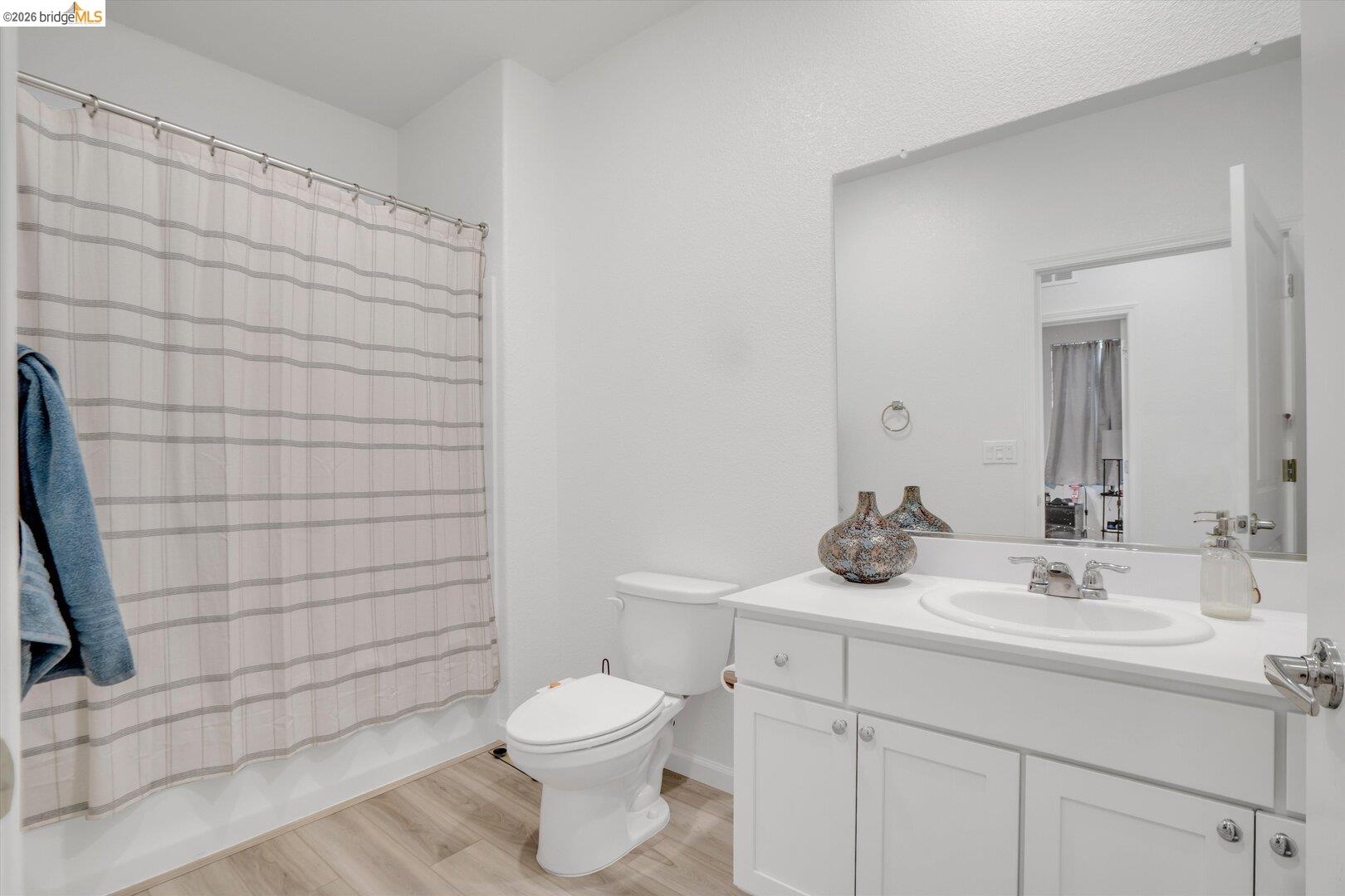 4463 Canada Way Rio Vista, CA 94571 - Photo 24 of 36 bathroom with vanity, shower / bath combo with shower curtain, and light wood-style flooring
