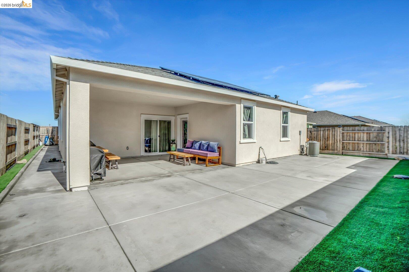 4463 Canada Way Rio Vista, CA 94571 - Photo 31 of 36 back of property featuring a fenced backyard, solar panels, stucco siding, a patio area, and an outdoor hangout area