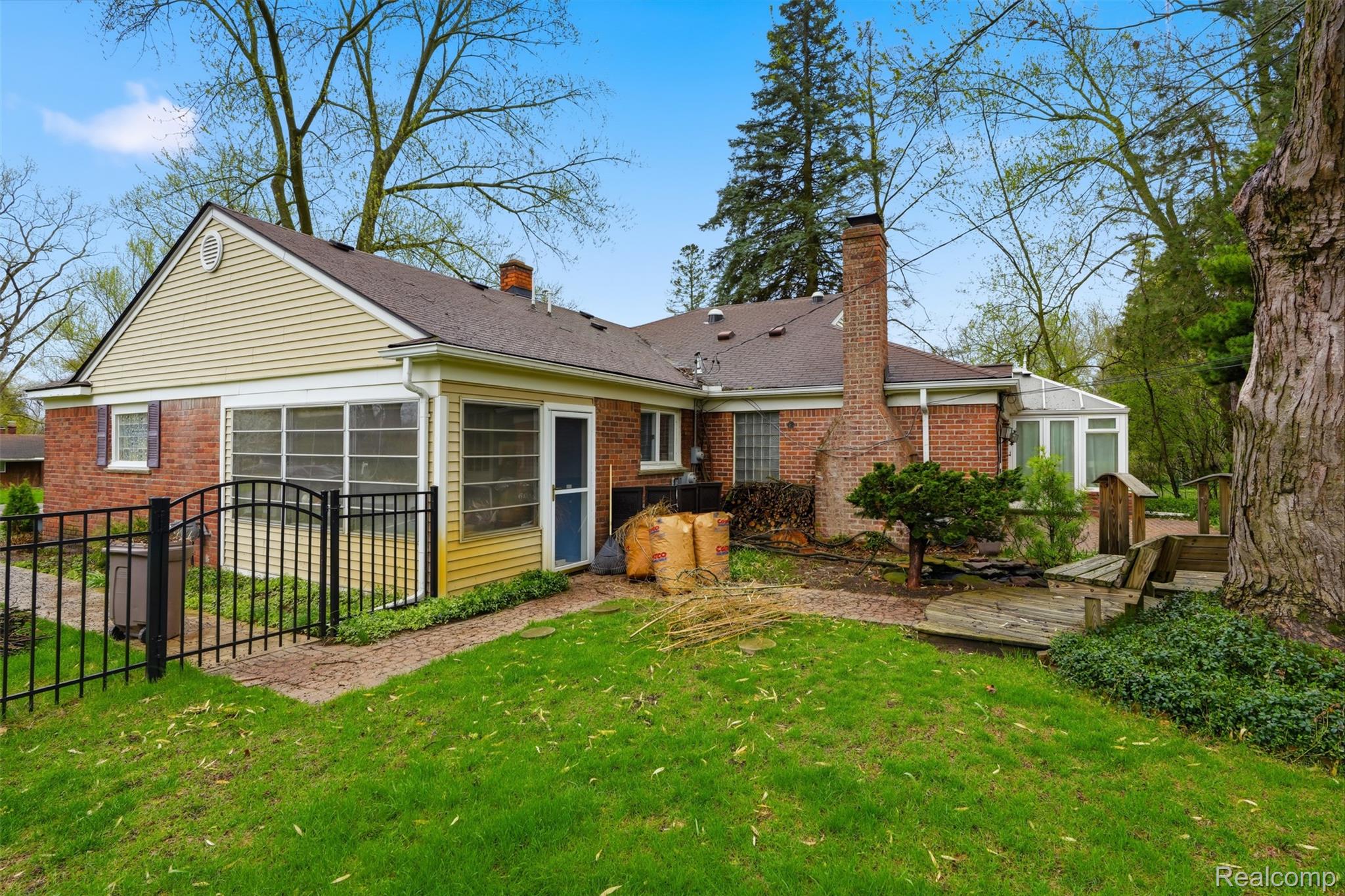2210 Lancaster Road Bloomfield Hills, MI 48302 - Photo 28 of 35 Rear view of house featuring a chimney, brick siding, and a sunroom
