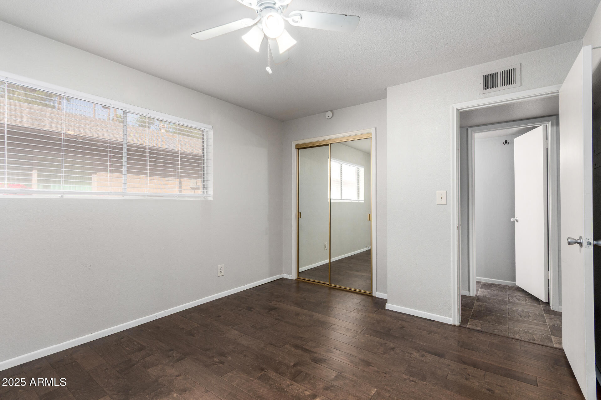 3031 South Rural Road, Unit 45 Tempe, AZ 85282 - Photo 19 of 28 an empty room with wooden floor and windows