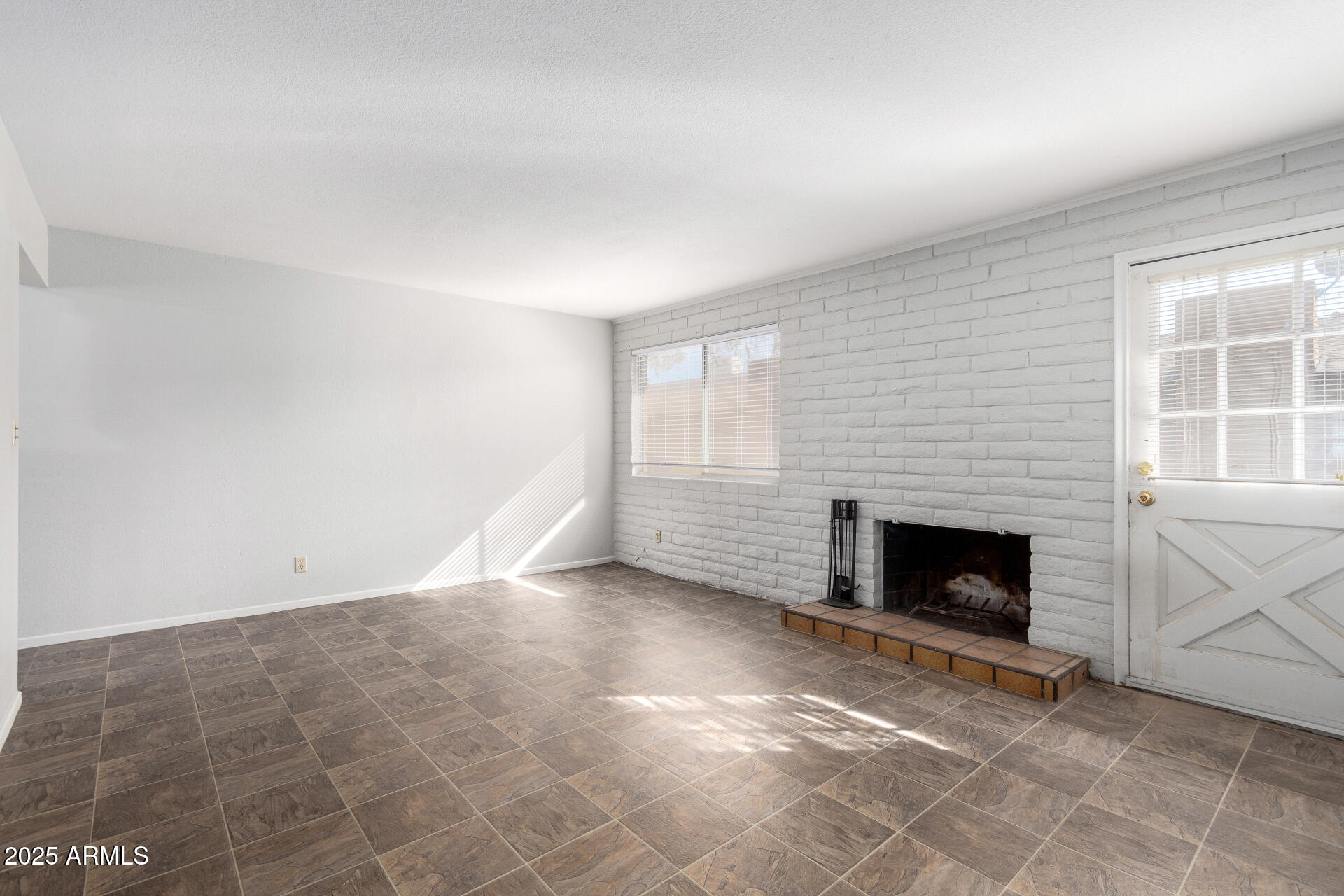 3031 South Rural Road, Unit 45 Tempe, AZ 85282 - Photo 2 of 28 an empty room with windows and fireplace