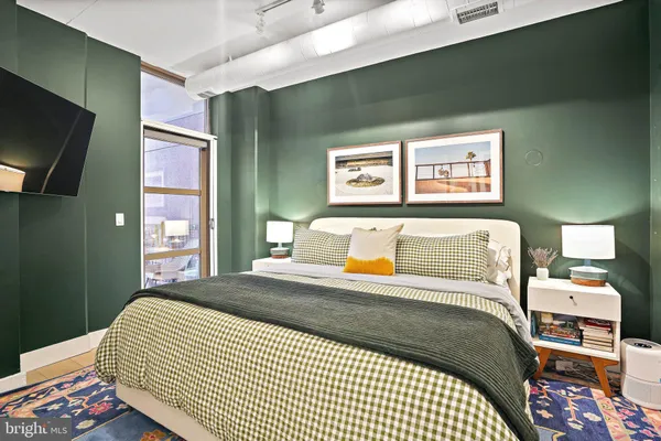 a bedroom with a bed and flat screen tv