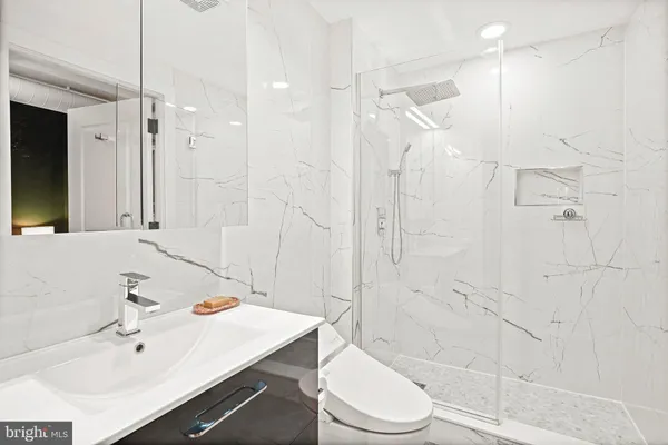 a bathroom with a sink a toilet and shower