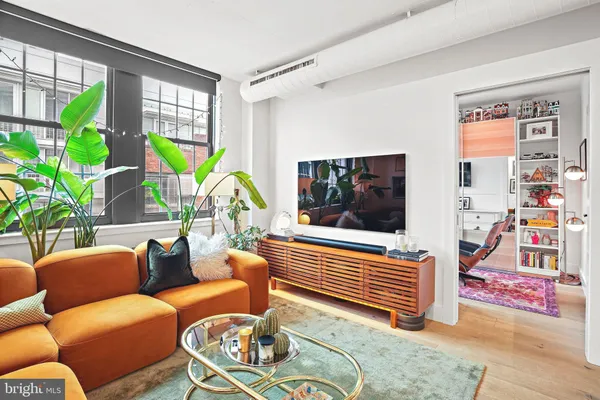 a living room with furniture a rug and a flat screen tv