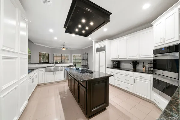 a kitchen with stainless steel appliances kitchen island granite countertop a stove and a sink