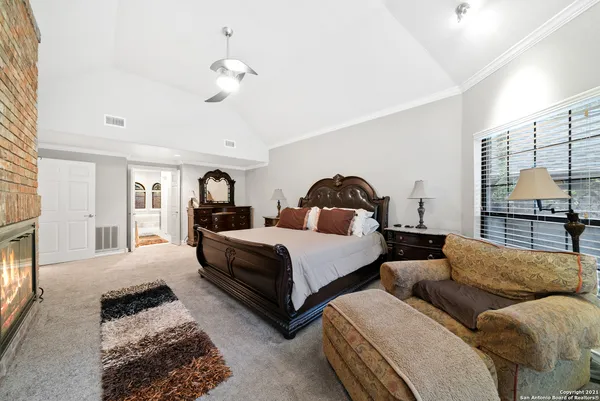 a bedroom with a bed a chandelier and a window