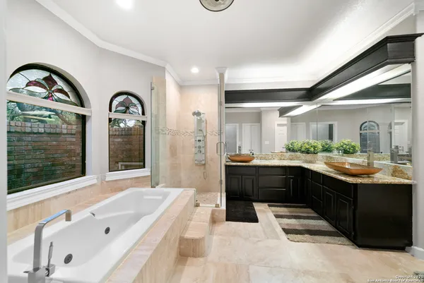 a large white bathroom with a large tub and sink