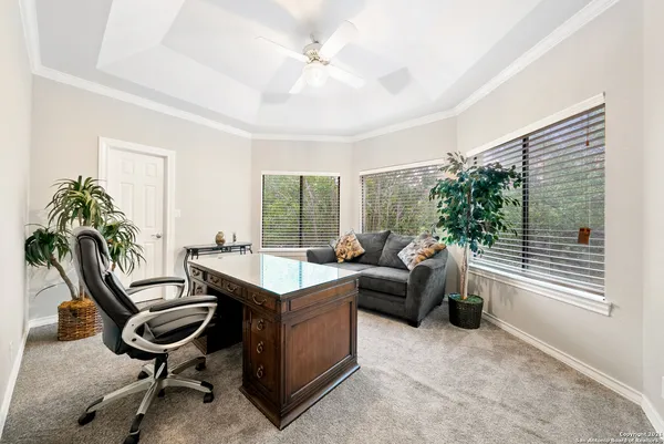 a view of a workspace with furniture and a window
