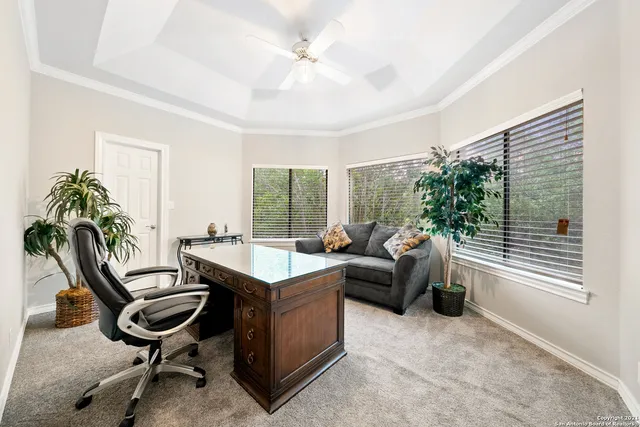 a view of a workspace with furniture and a window