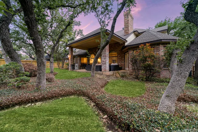 a front view of a house with a garden and trees