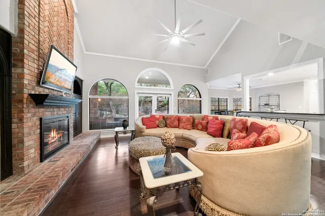 a living room with fireplace furniture and a large window