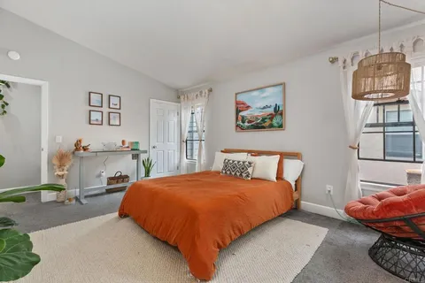 a bedroom with a bed mirror and window