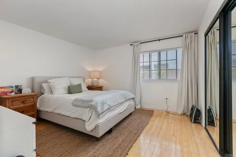 a bedroom with a bed and a large window