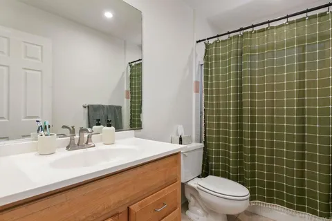 a bathroom with a sink a toilet a mirror and shower