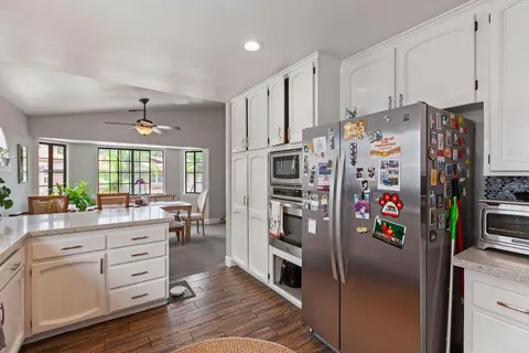 a kitchen with white cabinets and refrigerator