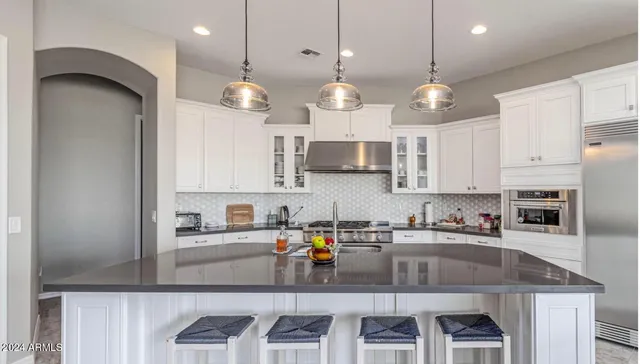 a kitchen with a table chairs refrigerator and cabinets